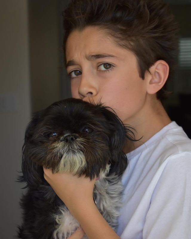 Picture of Nicolas Bechtel with his pet by wearing a white vest.